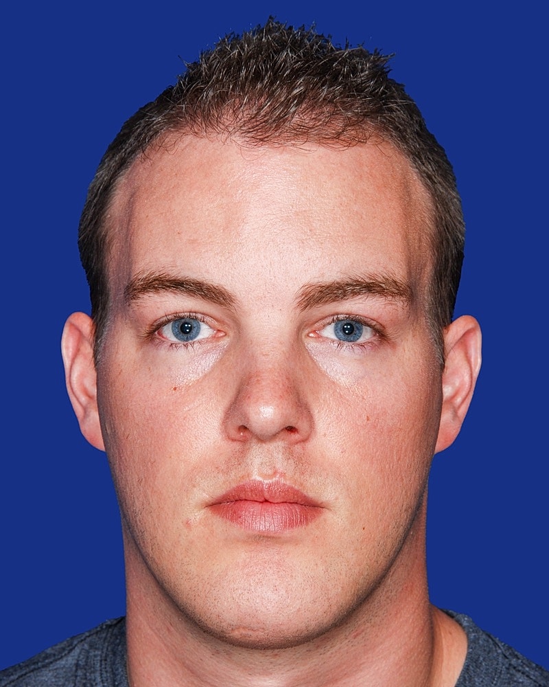 Person with short hair and blue eyes.