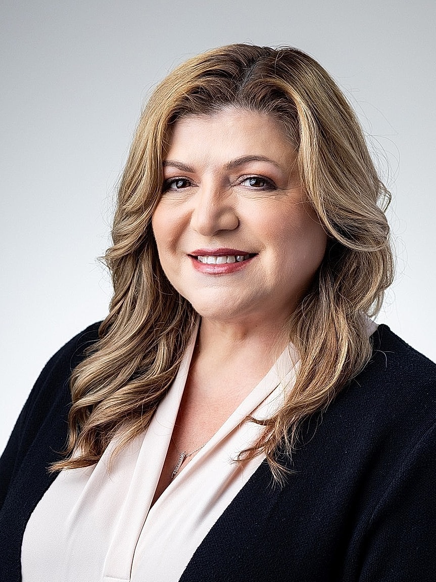 Professional portrait of a confident woman smiling.