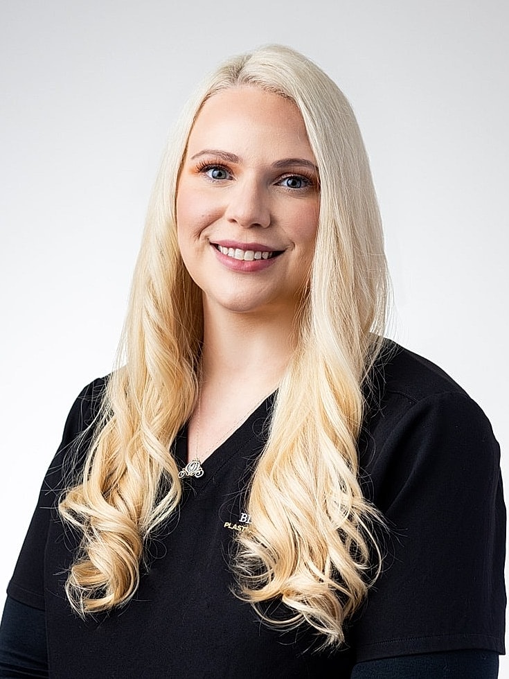 Smiling woman with long blonde hair in scrubs