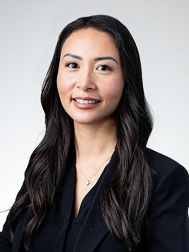 Professional woman with long dark hair smiling