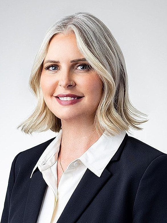 Professional woman smiling in business attire.