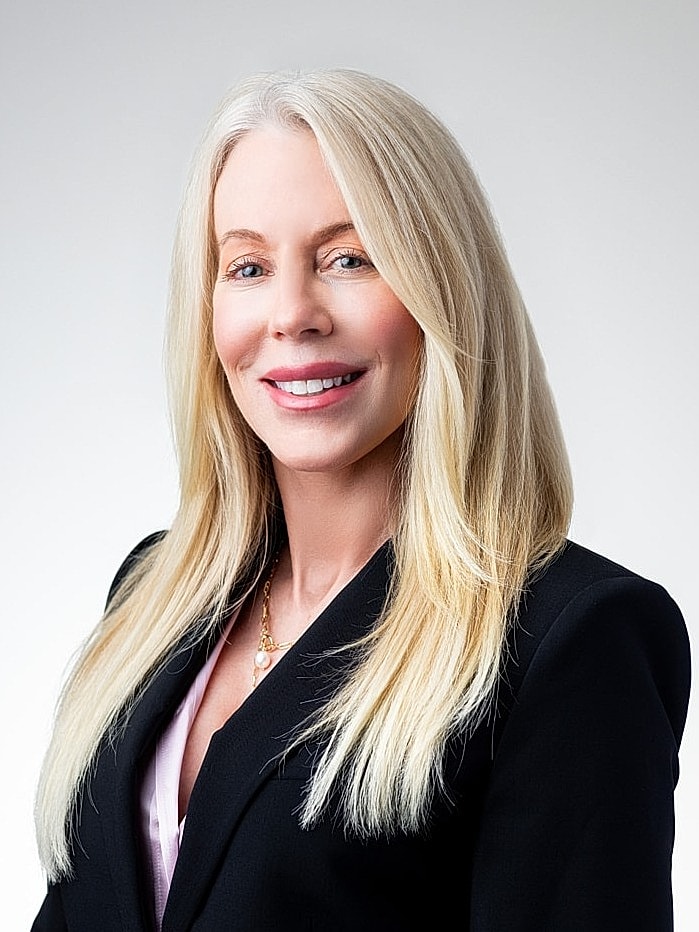 Professional woman smiling in business attire.