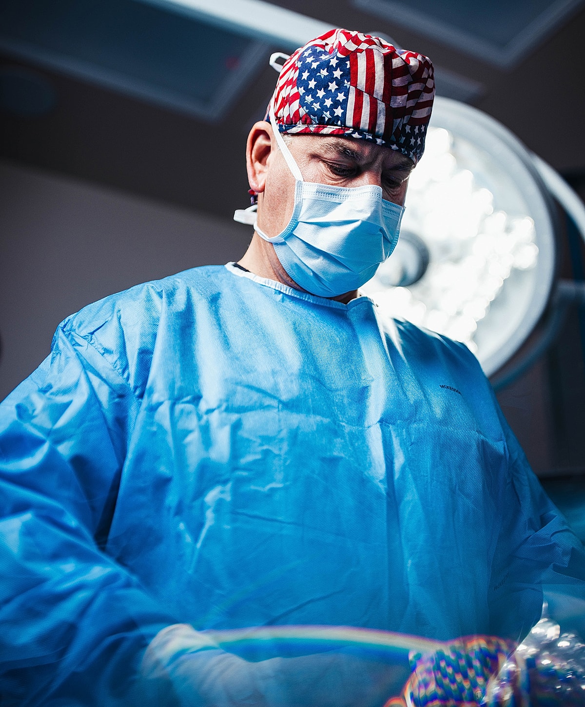 Surgeon in scrubs performing an operation.