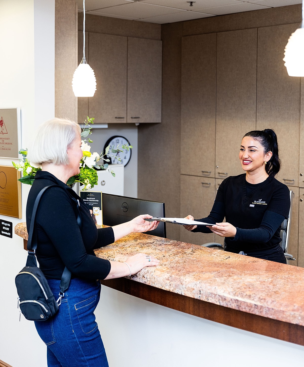 Receptionist assisting client at the front desk.