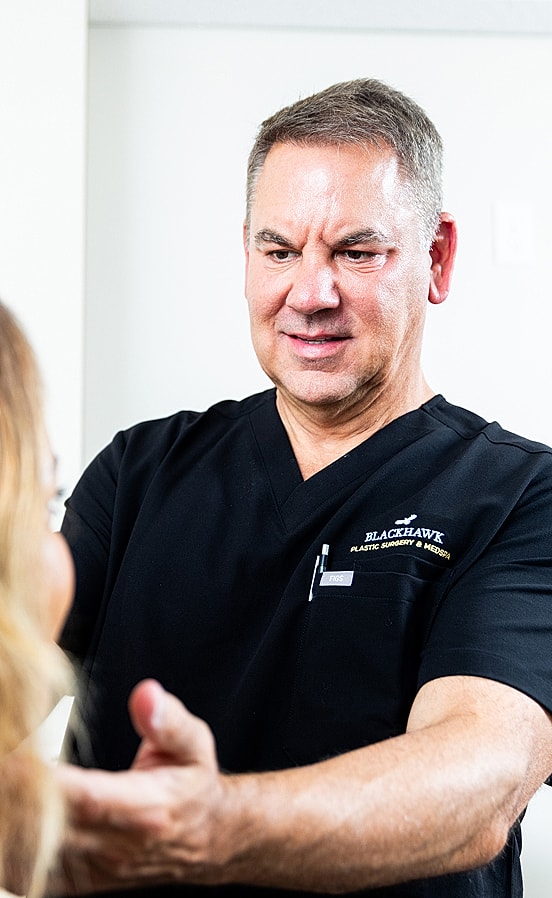 Plastic surgeon consulting with patient in office.
