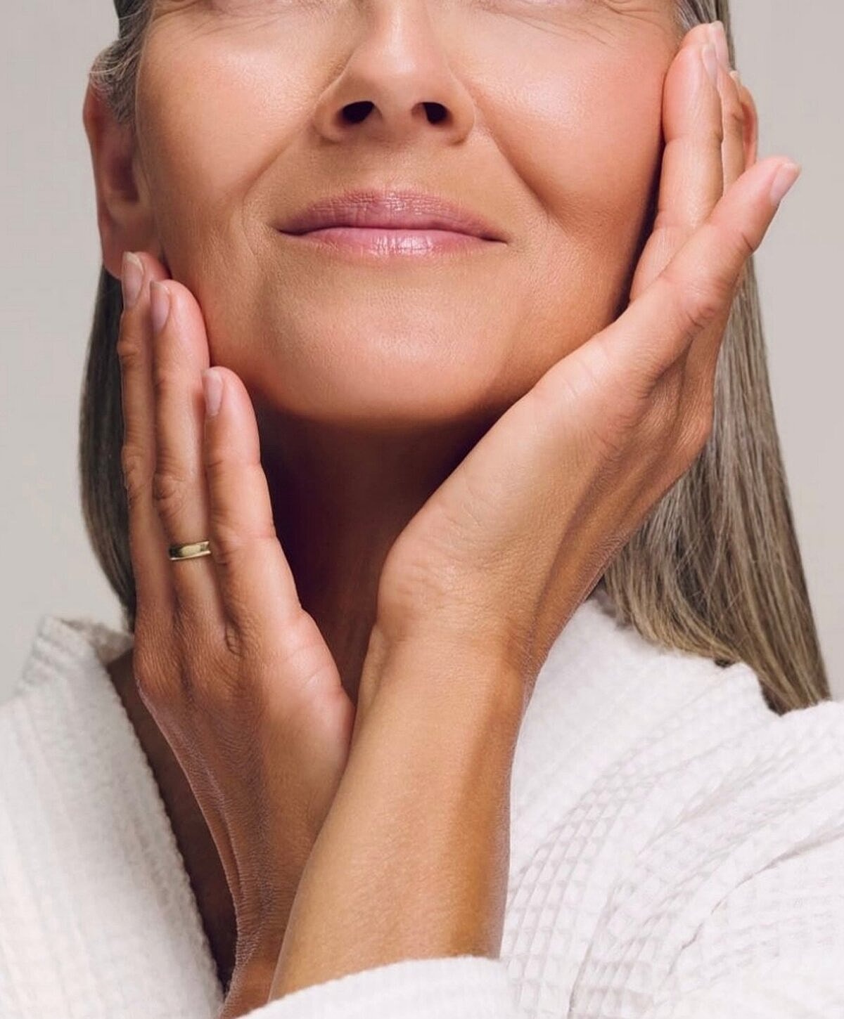 Woman gently touching her face, serene expression.
