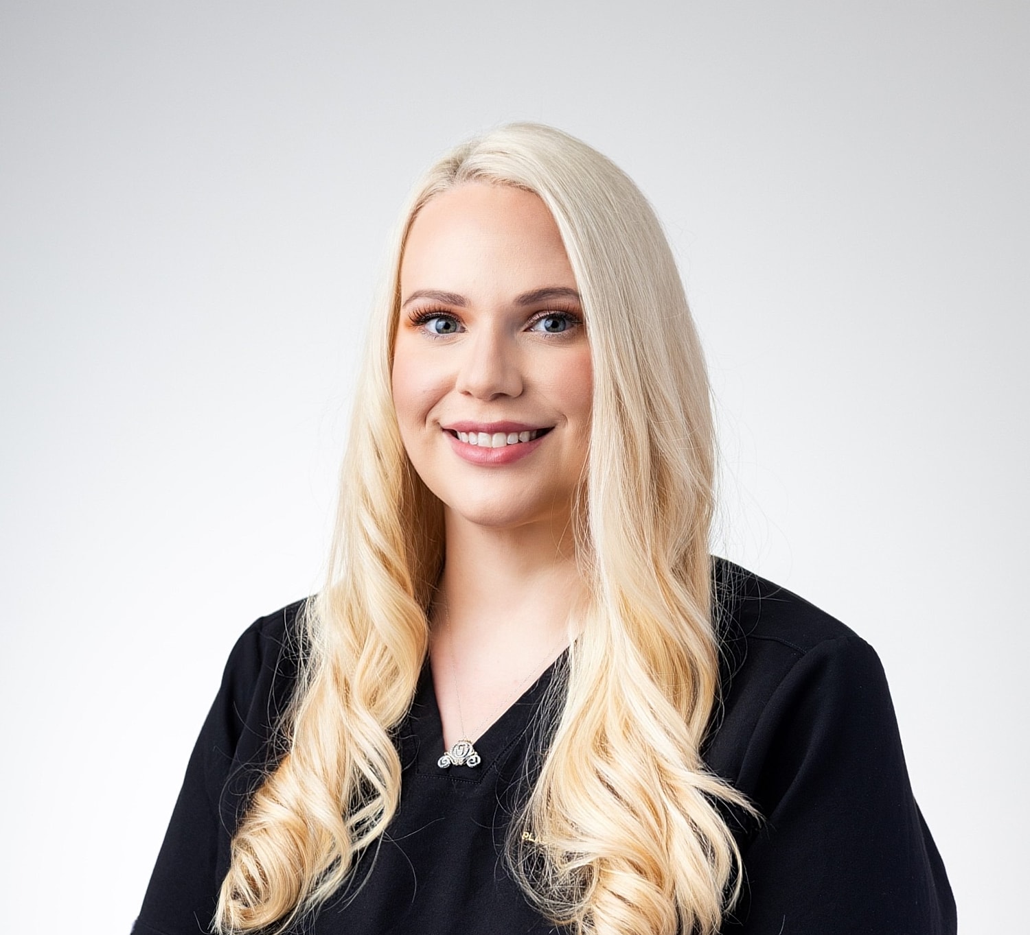 Smiling woman with long blonde hair in uniform.
