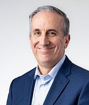Smiling man in a blue suit, professional portrait.