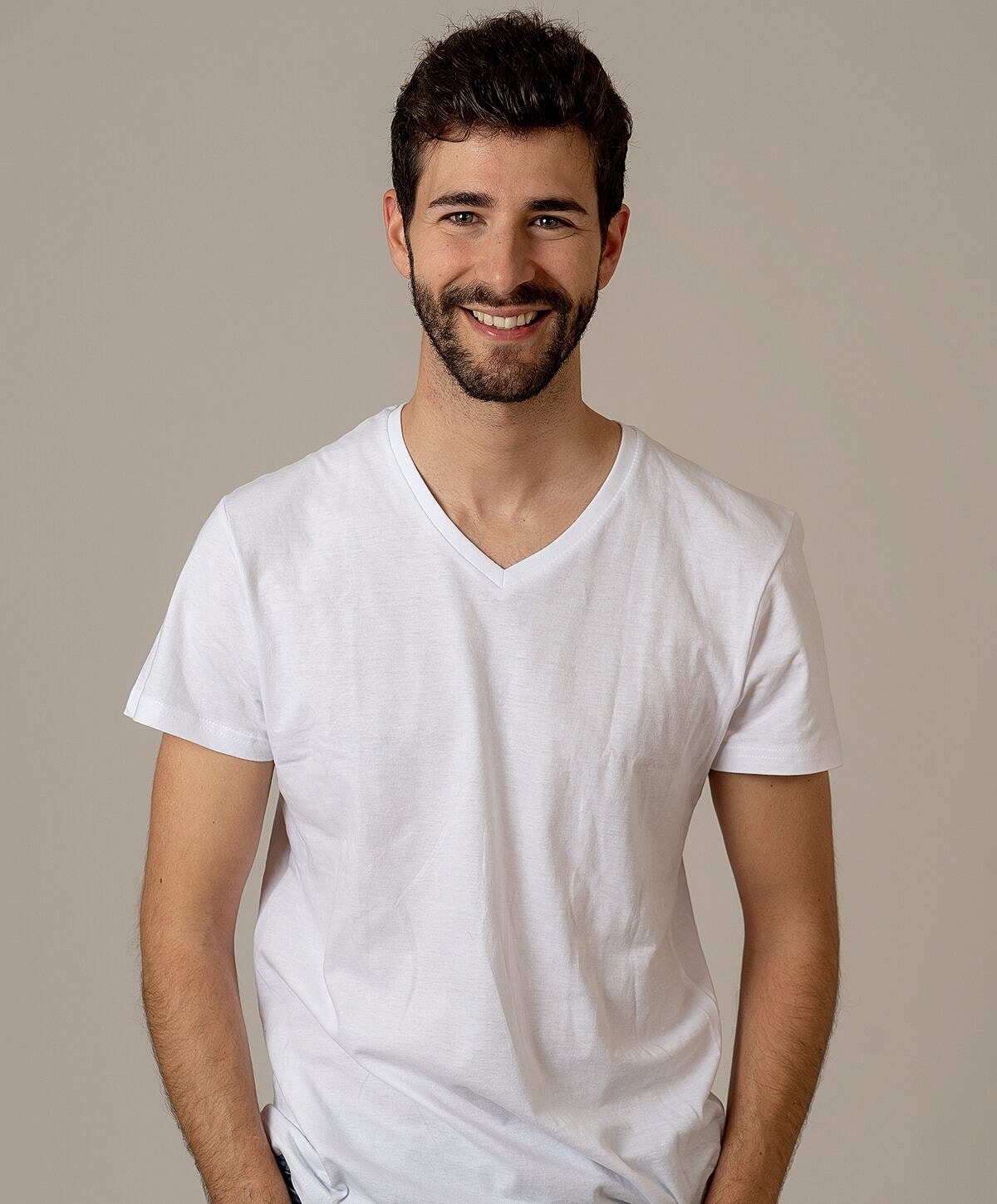 Smiling man in a white v-neck t-shirt.