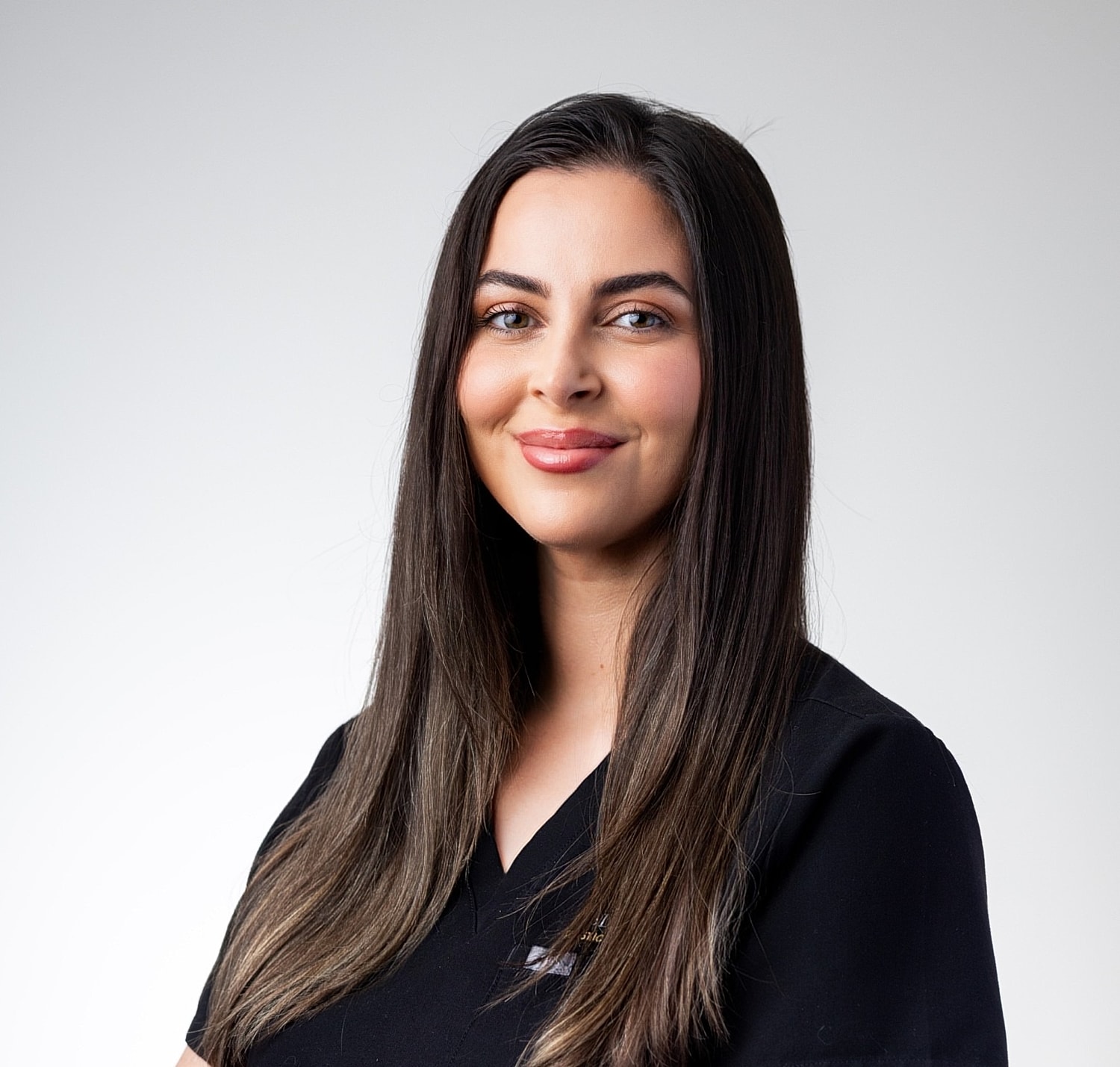 Professional woman smiling in healthcare uniform.