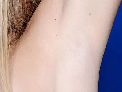 Close-up of smooth, bare skin against blue background.