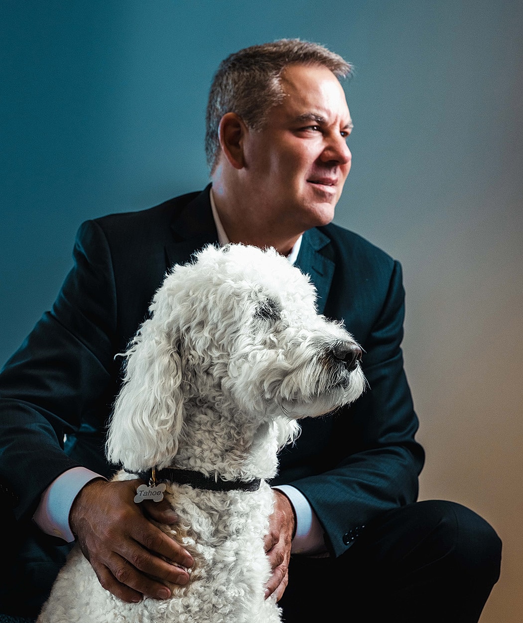Man in suit with white fluffy dog.