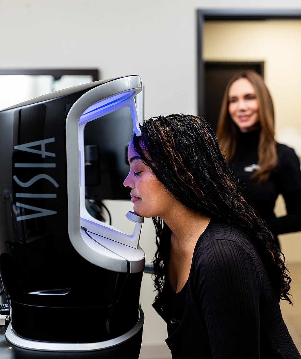 Woman using VISIA skin analysis machine.