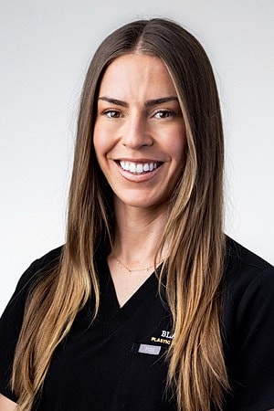 Smiling healthcare professional in black attire.