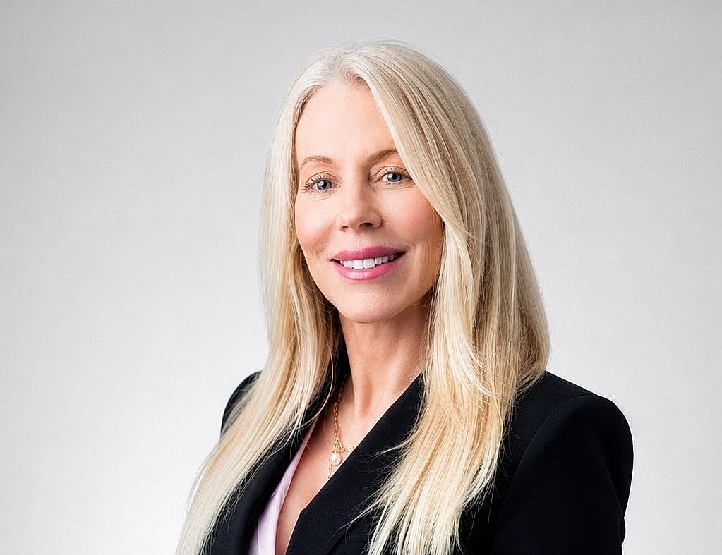 Professional woman in tailored suit, smiling confidently.