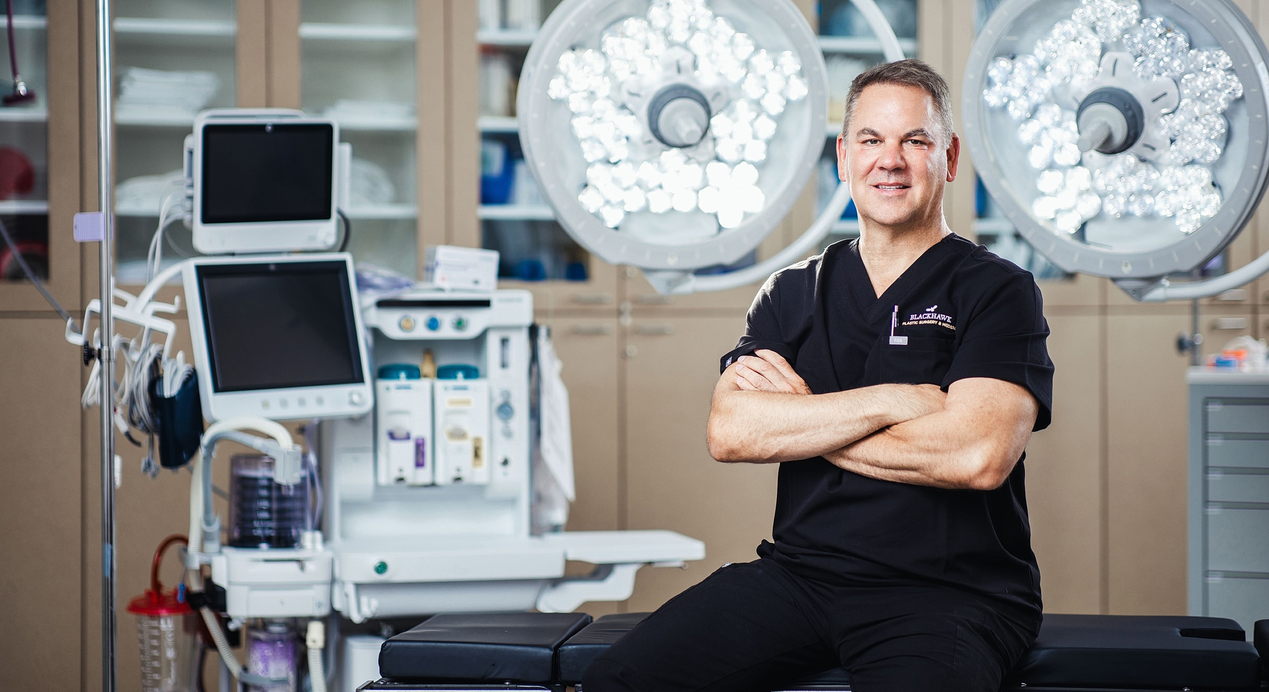 Surgeon in scrubs in a medical environment.