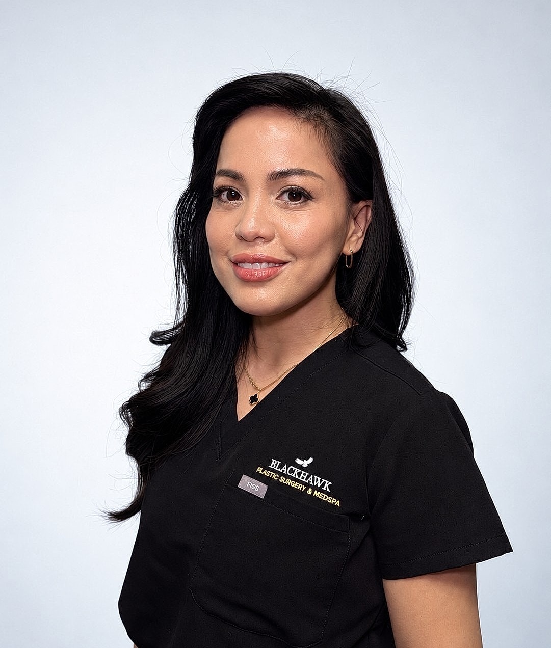 Medical professional in scrubs against light background