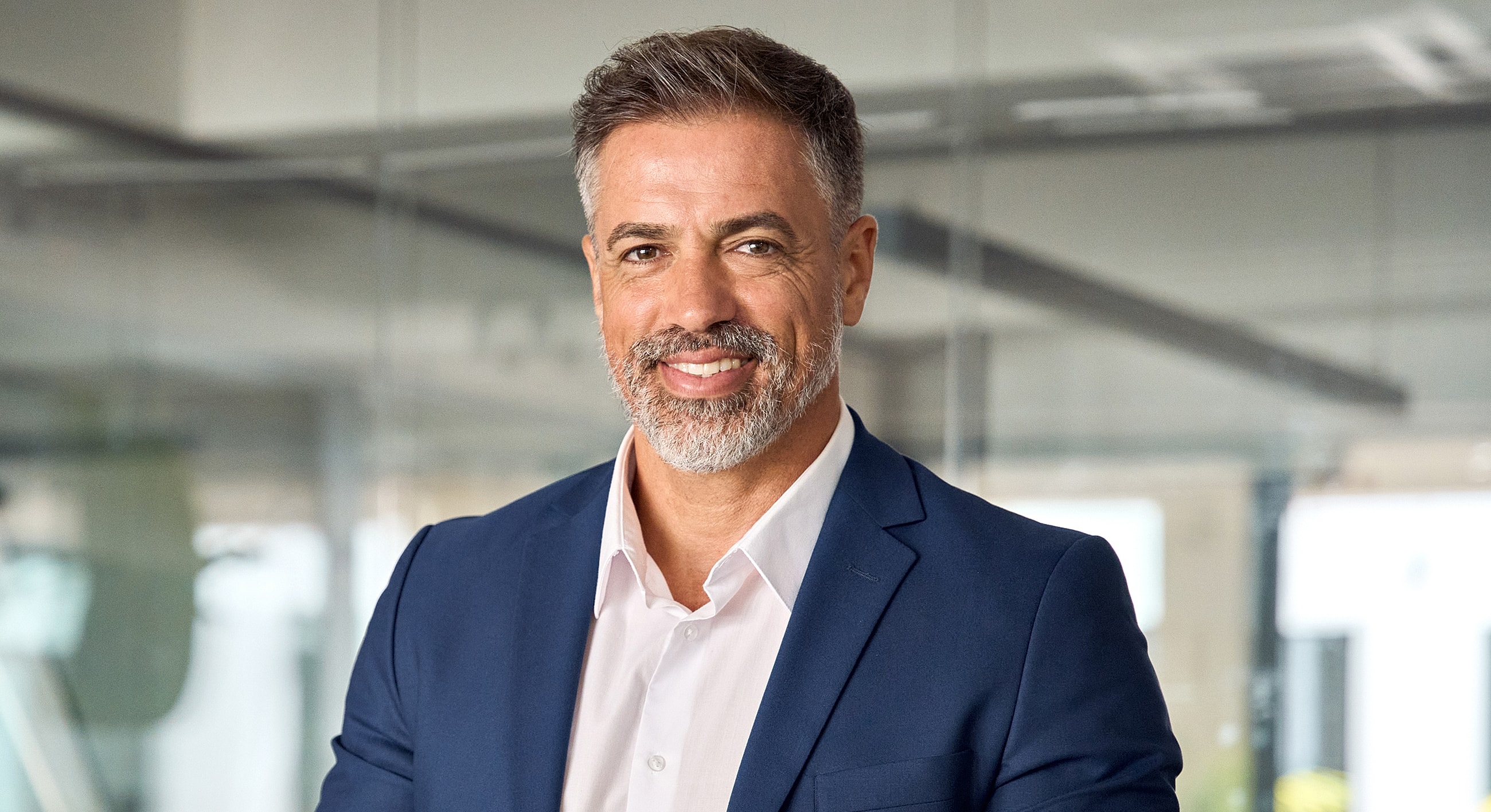Smiling man in professional attire, office background.