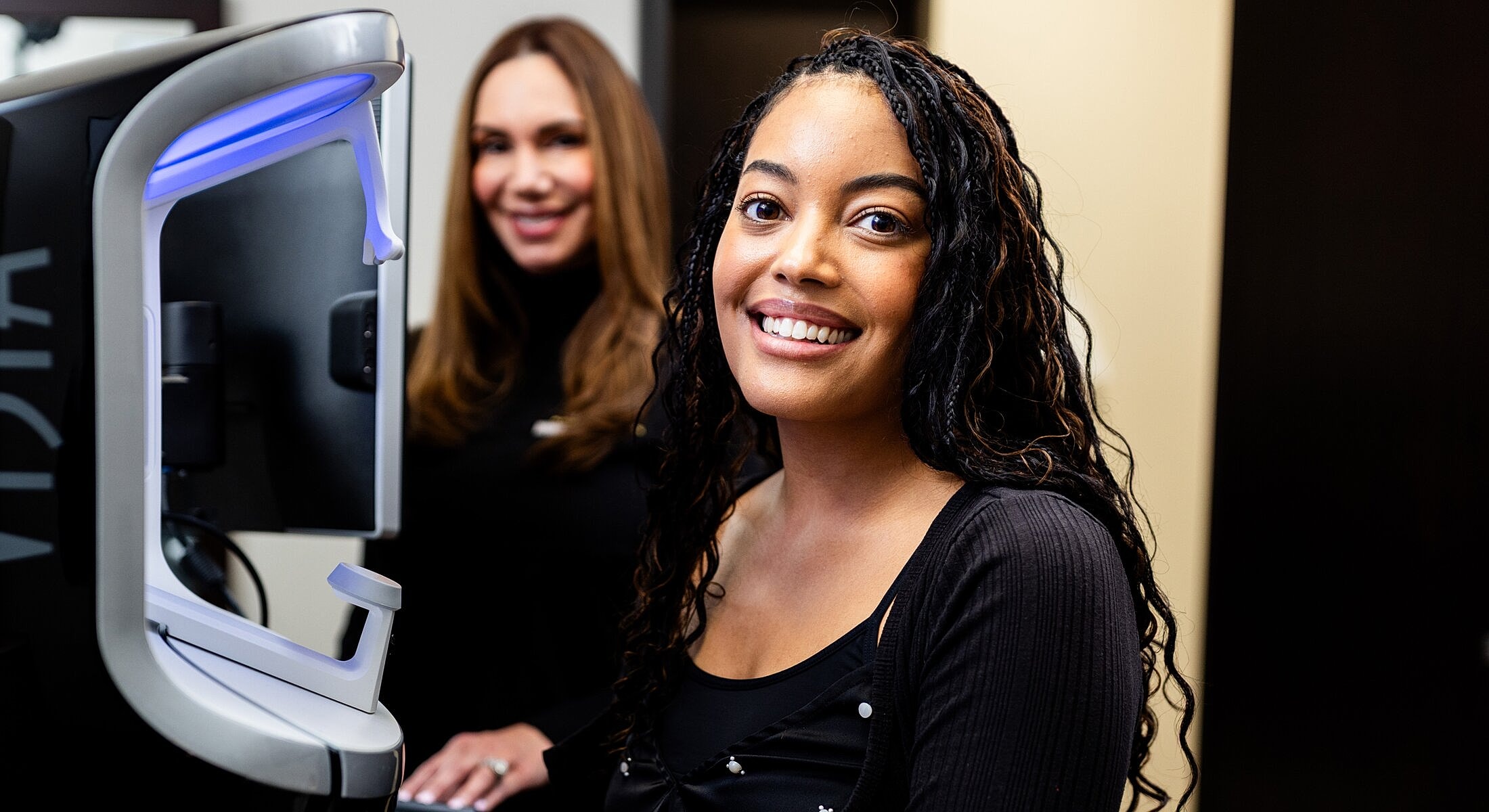 Two women smiling in a professional setting.