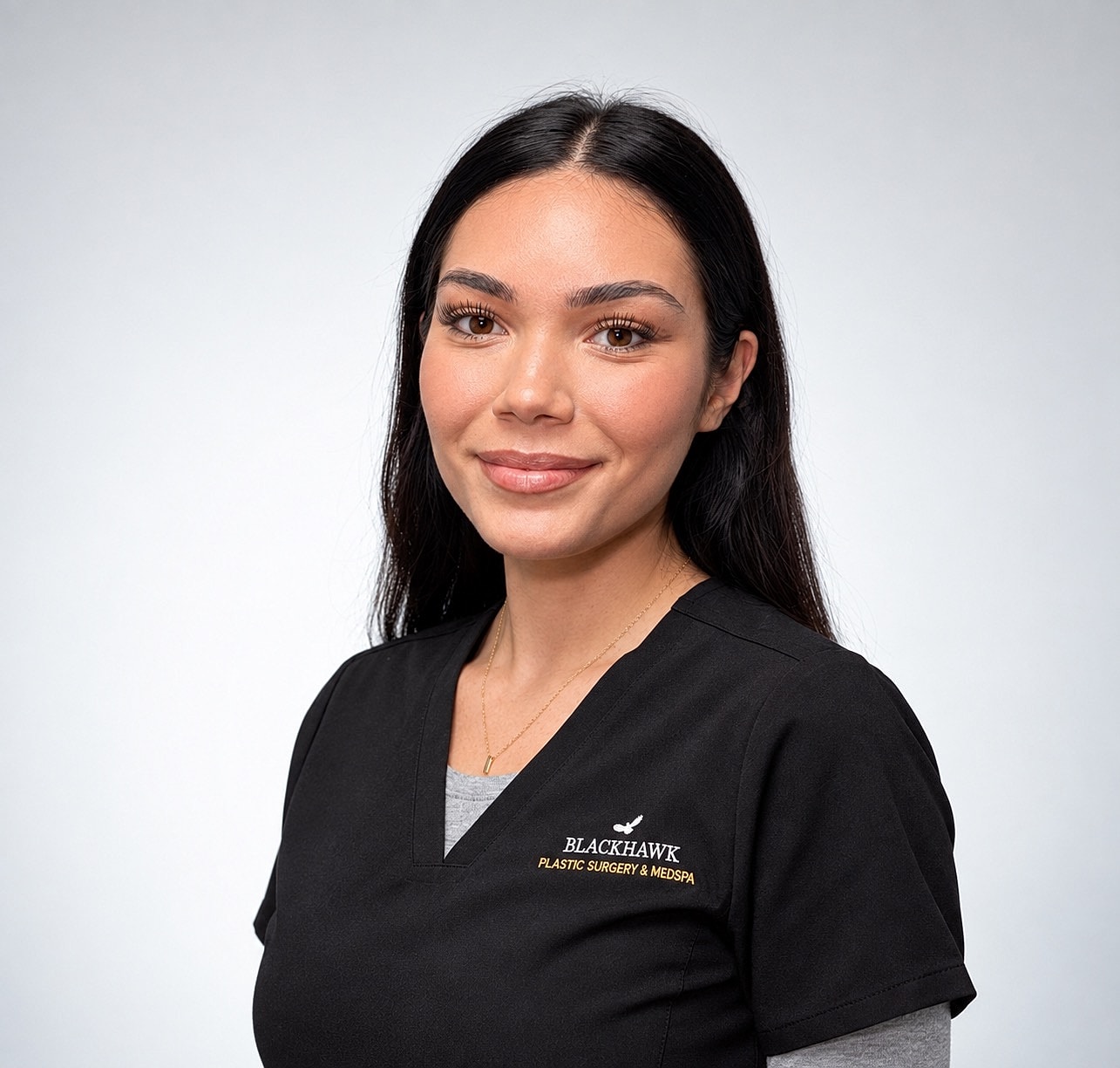Medical professional in scrubs smiling confidently.