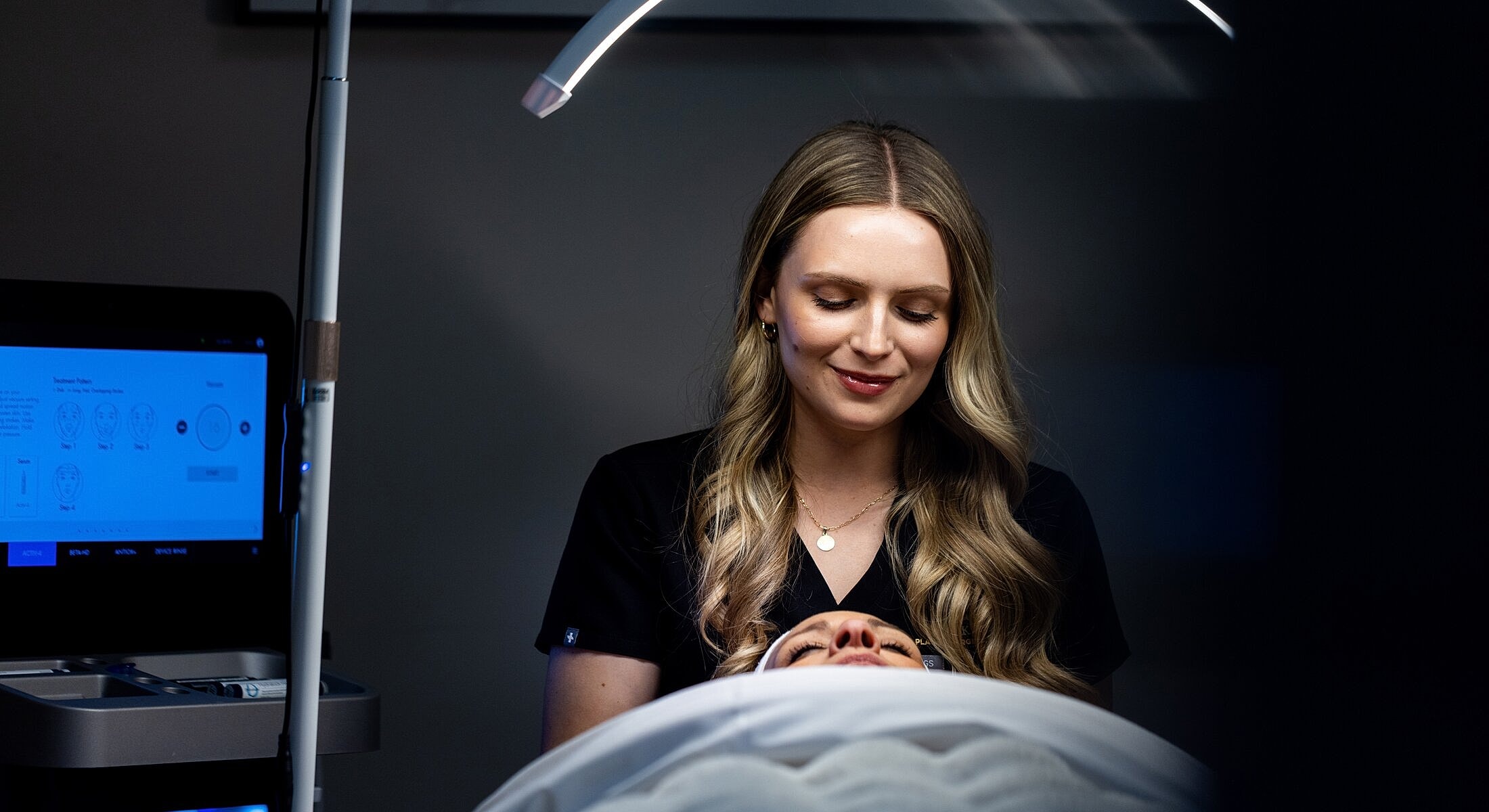 Dermatologist performing a facial treatment on a patient.