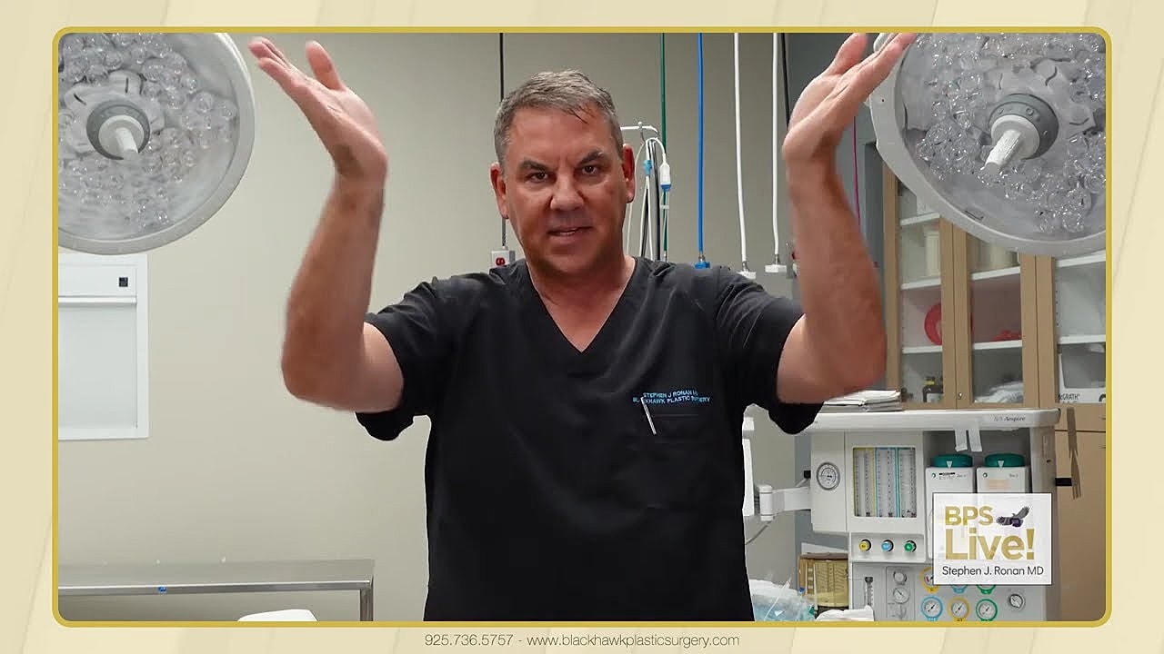 Surgeon demonstrating techniques in operating room setting.