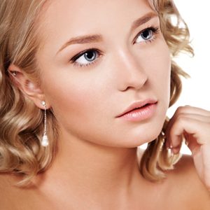 Portrait of young beautiful female with perfect pure skin, natural make-up and professional hairstyle